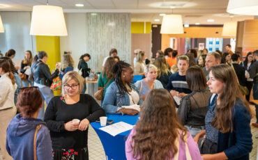 de nombreuses personnes discutent discutent autour de tables hautes